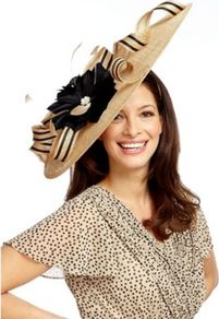 Caramel Statement Hatinator - predominant colour: camel; secondary colour: black; occasions: evening, occasion; type of pattern: large; style: wide brimmed; size: large; material: macrame/raffia/straw; pattern: plain; trends: sculptural frills; embellishment: corsage